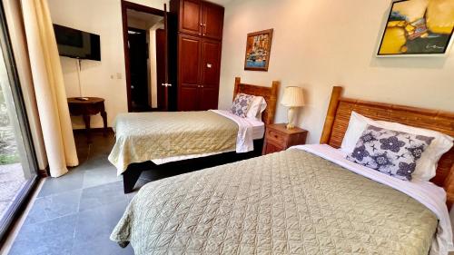 a hotel room with two beds and a television at Monte Carlo Luxury Condominiums in Jacó