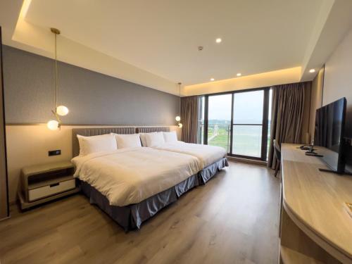 a bedroom with a large bed and a television at Moonshine Inn in Daxi