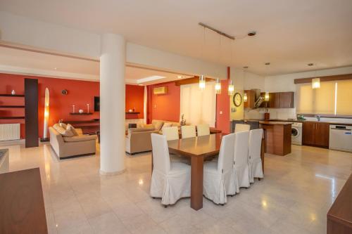 a kitchen and dining room with a table and chairs at Hallmark Beach by TrulyCyprus in Limassol