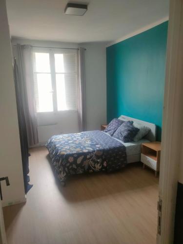 une chambre avec un lit et un mur bleu dans l'établissement Marseille: logement entier à 2 pas du vieux port, à Marseille