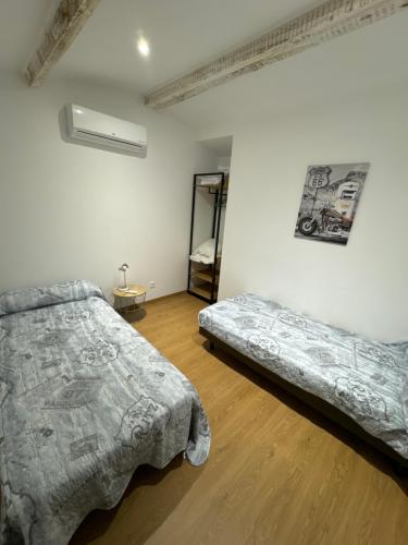 une chambre avec deux lits et un miroir au mur dans l'établissement Villa Chemakhi 10 personnes, à Narbonne