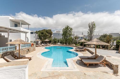 a pool at a resort with chairs and umbrellas at Hotel Francesca in Agios Prokopios