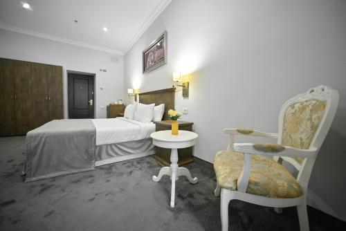 a hotel room with a bed and a chair at Address Hotel Yerevan by Imperial in Yerevan