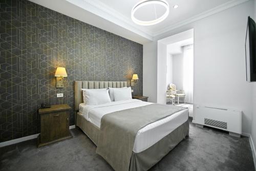 a bedroom with a large bed and a wall at Address Hotel Yerevan by Imperial in Yerevan