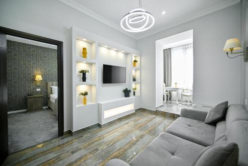 a living room with a couch and a television at Address Hotel Yerevan by Imperial in Yerevan