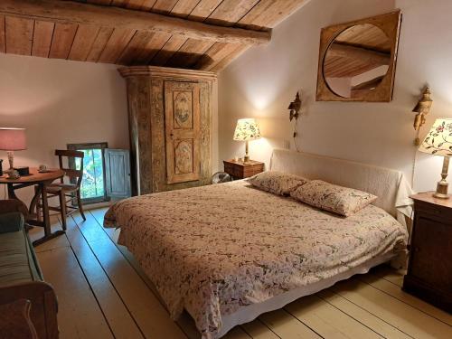 a bedroom with a bed and a table and a chair at Le Mas du Lac in Uzès