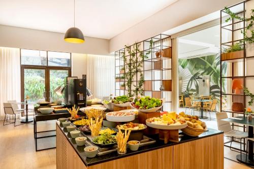 a buffet with many bowls of food on a table at Grand Mercure SP Itaim Bibi in São Paulo