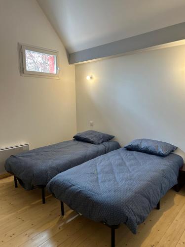deux lits jumeaux dans une chambre avec fenêtre dans l'établissement Gîte Lilas 4-6 personnes, à La Salvetat-sur-Agout