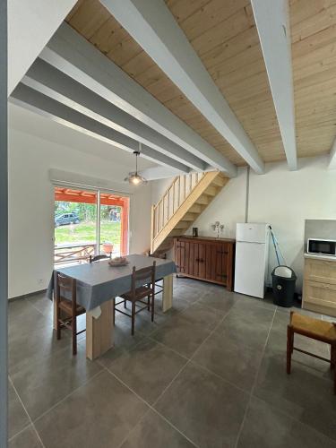 une salle à manger avec une table et une cuisine dans l'établissement Gîte Lilas 4-6 personnes, à La Salvetat-sur-Agout
