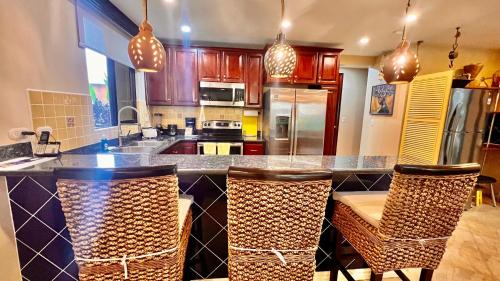 a kitchen with a bar with chairs and a counter top at Monte Carlo Luxury Condominiums in Jacó