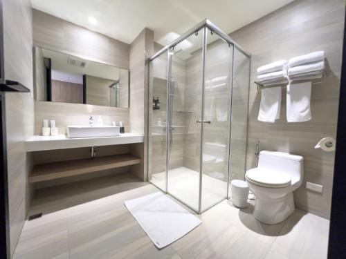 a bathroom with a shower and a toilet and a sink at Moonshine Inn in Daxi