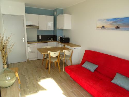 un salon avec un canapé rouge et une table dans l'établissement Studio cabine - Quartier de l'Aiguillon - 2 à 4 personnes, à Arcachon