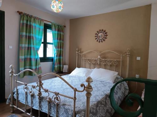 a bedroom with a metal bed and a clock on the wall at Seaside Apartment 2 in Emborios