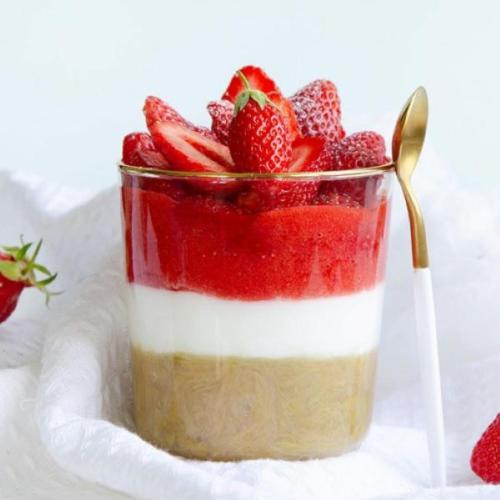 a dessert with strawberries in a cup with a spoon at Lou Baralet Chambres d'hôtes et Restaurant in Roujan