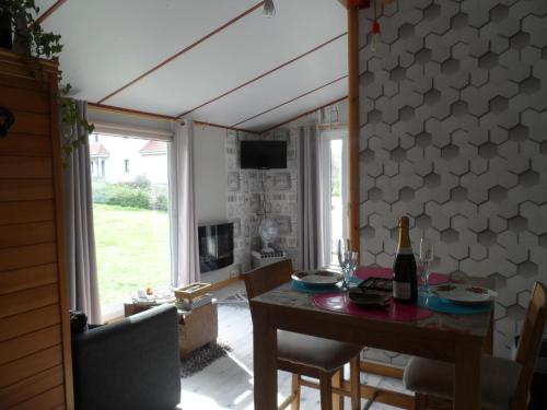 a dining room with a table with a bottle of wine at le haut village chambres d'hôtes en baie de somme in Arrest