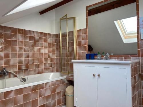 uma casa de banho com uma banheira e um lavatório em Sous le bon Toit em Belley