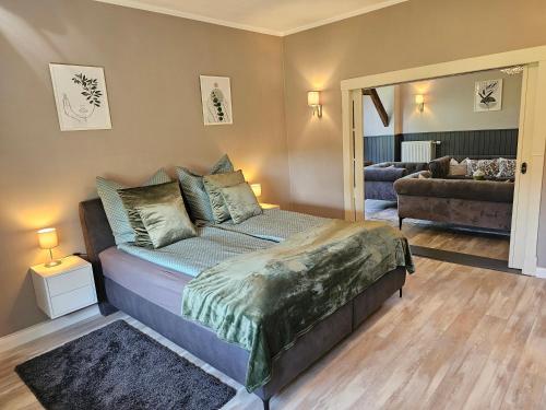 a bedroom with a bed and a couch and a mirror at Ferienhaus Fehntraum - Entdecke Ostfriesland in Großefehn 