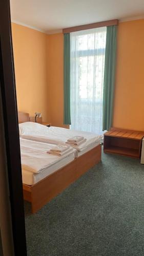 a small bedroom with a bed and a window at Grandhotel Nový Bor in Nový Bor