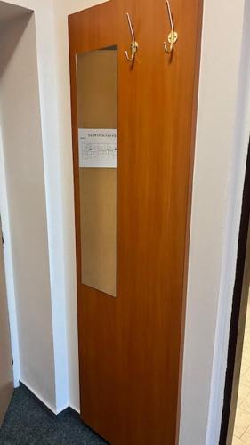 a wooden door in a hallway with a sign on it at Grandhotel Nový Bor in Nový Bor