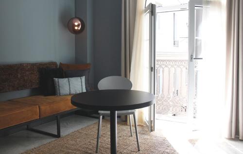 a table in a room with a chair and a lamp at Apartamentos NONO by Charming Stay in Málaga