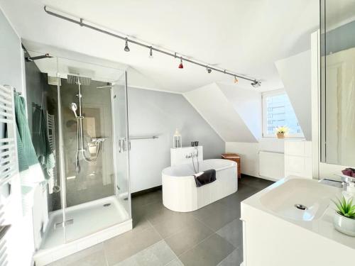 Un baño blanco con ducha y lavabo. en Tolle 2 Zimmer Wohnung Nähe ICE, en Siegburg