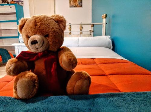 un ours en peluche brun assis sur un lit dans l'établissement 
