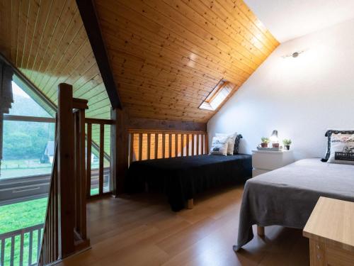 une chambre avec deux lits et une grande fenêtre dans l'établissement Appartement calme près du centre et pistes, balcon sud, navette gratuite - FR-1-296-168, à Saint-Lary-Soulan