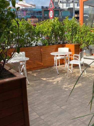 a patio with a table and chairs and plants at iNALENS AİRPORT HOTEL in Arnavutköy