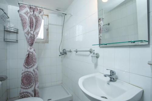a bathroom with a sink and a toilet and a mirror at Tinas Dreams By The Sea in Afantou