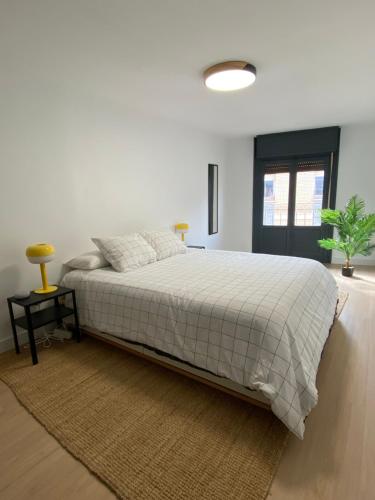 1 dormitorio blanco con 1 cama grande con alfombra en Haro Plaza Centro, en Haro