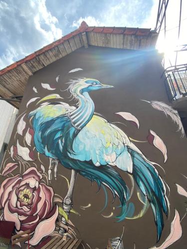 a painting of a peacock on the side of a building at Les Chambres de l'Imprimerie in Beaune