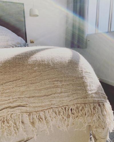 a bed with a white blanket on top of it at Les Chambres de l'Imprimerie in Beaune