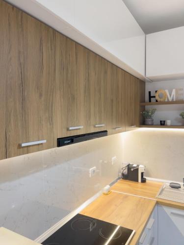a kitchen with wooden cabinets and a counter top at Boulevard Apartaments - Vlora in Vlorë