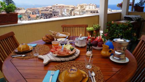 - une table en bois avec de la nourriture sur le balcon dans l'établissement B&B Il Vicolo Di Pizzo, à Pizzo