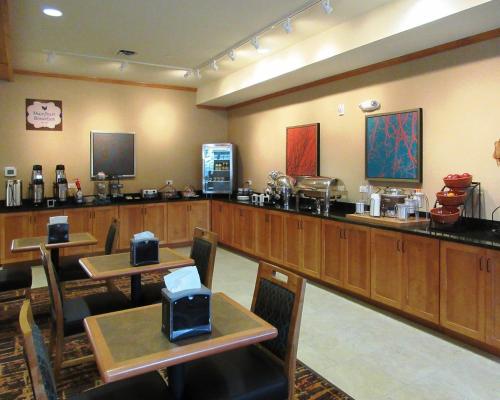 a restaurant with tables and a bar with a counter at MainStay Suites Sidney - Medical Center in Sidney