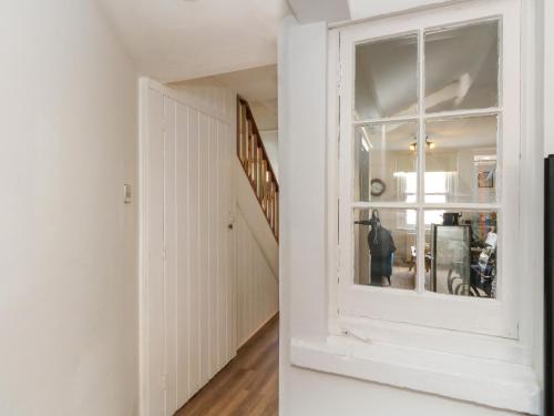un couloir avec une porte blanche et une fenêtre dans l'établissement 26 High West, à Weymouth