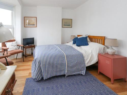 une chambre avec un lit avec une couverture bleue et blanche dans l'établissement 26 High West, à Weymouth