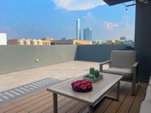 a table with a bowl of apples on a balcony at New PH for 6, BBQ and amazing private roof terrace in Mexico City