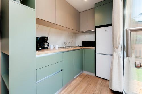 a kitchen with blue and white cabinets and a refrigerator at Glamping and Mobile Homes Lavanda - Holiday Centre Bi VIllage in Fažana