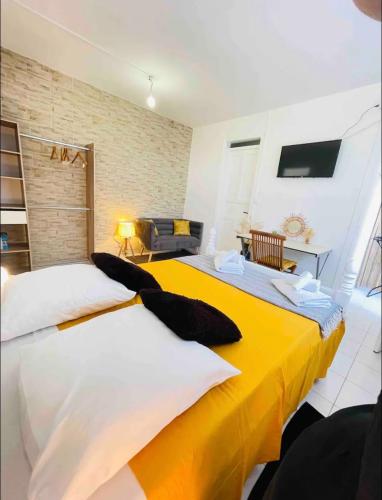 two beds in a room with a yellow blanket at Sunshine Privilège in Deshaies