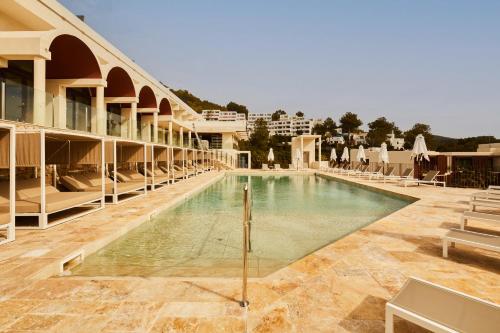 una piscina al centro di un edificio di Cala San Miguel Hotel Ibiza, Curio Collection by Hilton, Adults only a Puerto de San Miguel