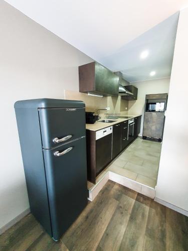 - une cuisine avec un réfrigérateur noir dans la chambre dans l'établissement Les Fermes de Cal Panche : Le Bas de Chalet, aux Angles