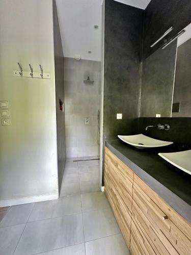 une salle de bain avec deux lavabos et une douche dans l'établissement L Oasis, à Le Pellerin