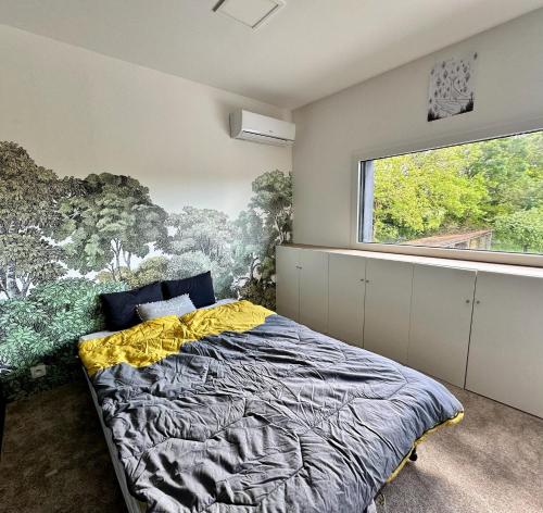 une chambre avec un lit et une grande fenêtre dans l'établissement L Oasis, à Le Pellerin