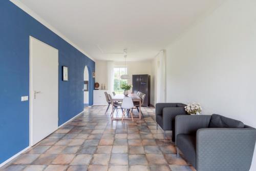 a living room with blue walls and a table and chairs at Comfort Villa for 8 People in Zeewolde