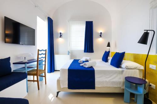 a hotel room with a bed and a table and a chair at AMORE RENTALS - Villa Olivella in Anacapri
