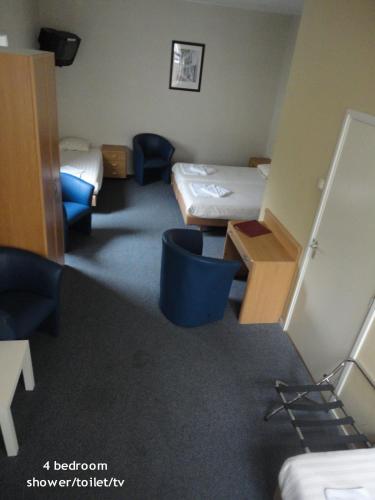 a room with two beds and a desk in it at Hotel 't Anker in Leeuwarden