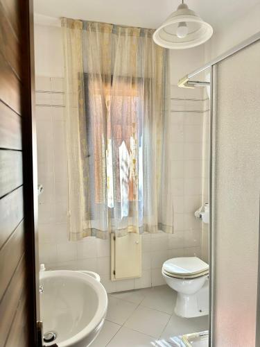 a white bathroom with a sink and a toilet at Moresca Apartment by Jennas in Àrbatax