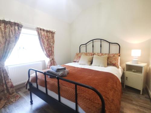 Christie's Cottage في Dungiven: غرفة نوم بسرير ونافذة