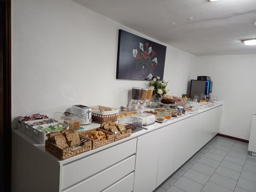 ein Buffet mit Brot und Körben mit Speisen in der Unterkunft Beira Rio do Gerês in Geres